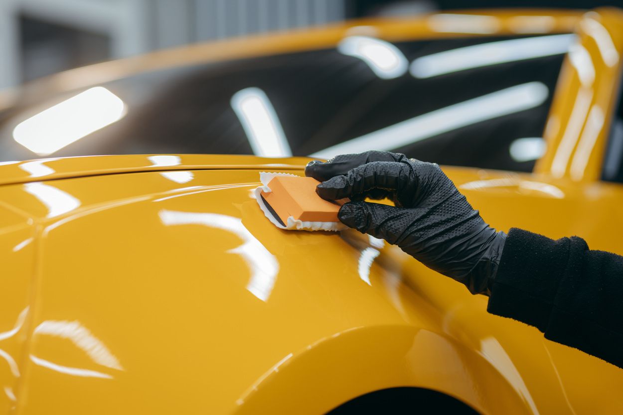 applying ceramic coating on yellow car